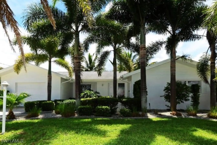 Ranch-style home featuring a front yard, an attach