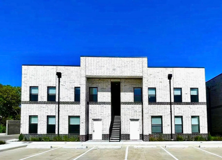 View of apartment building / complex with uncovered parking and stairs