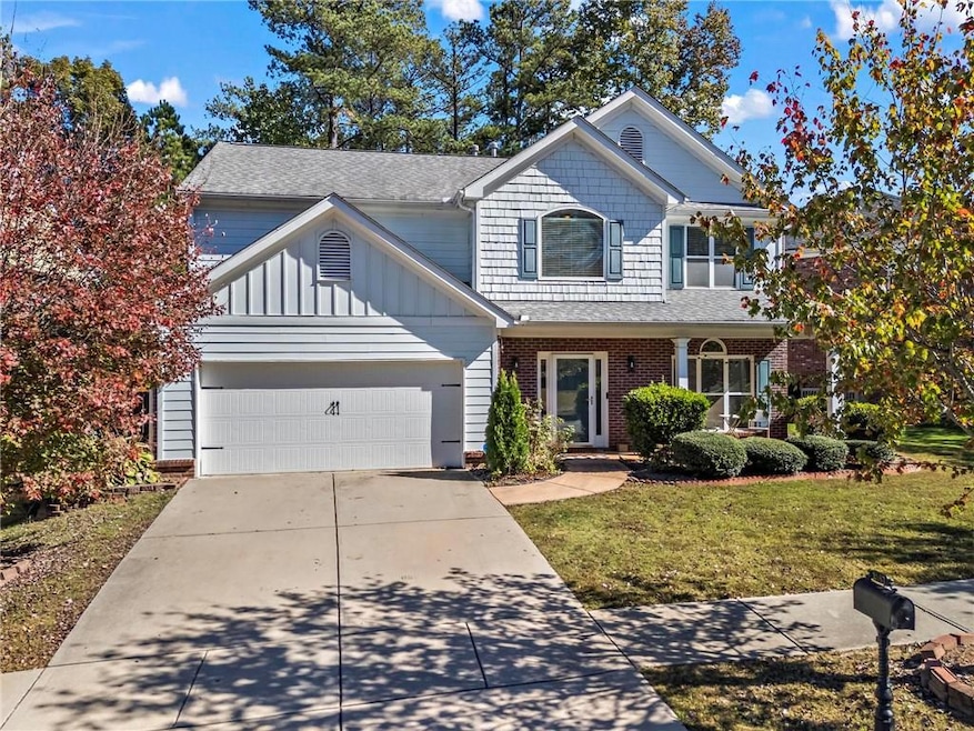 Traditional home with a garage, driveway, brick si