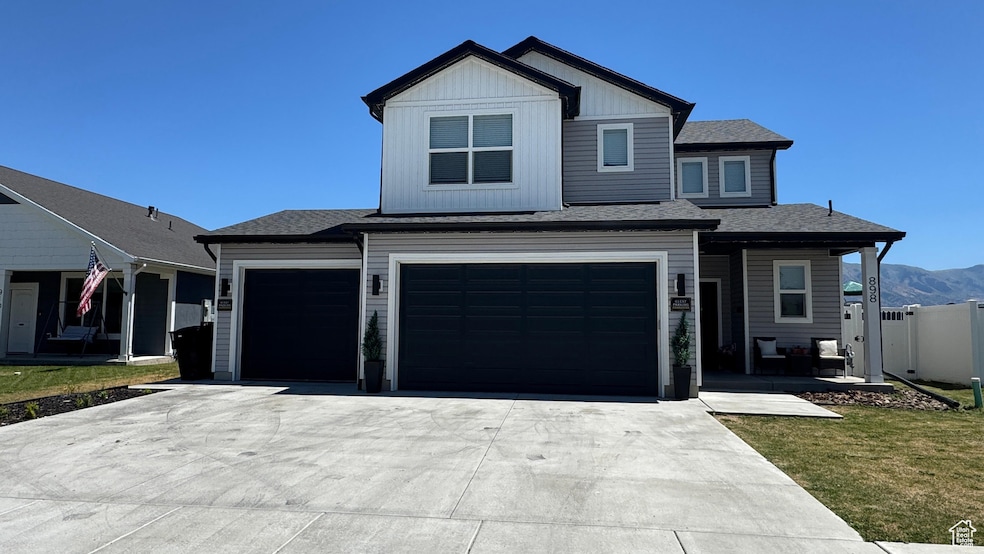 View of front facade with driveway, a shingled roof, an attached garage, and a mountain view