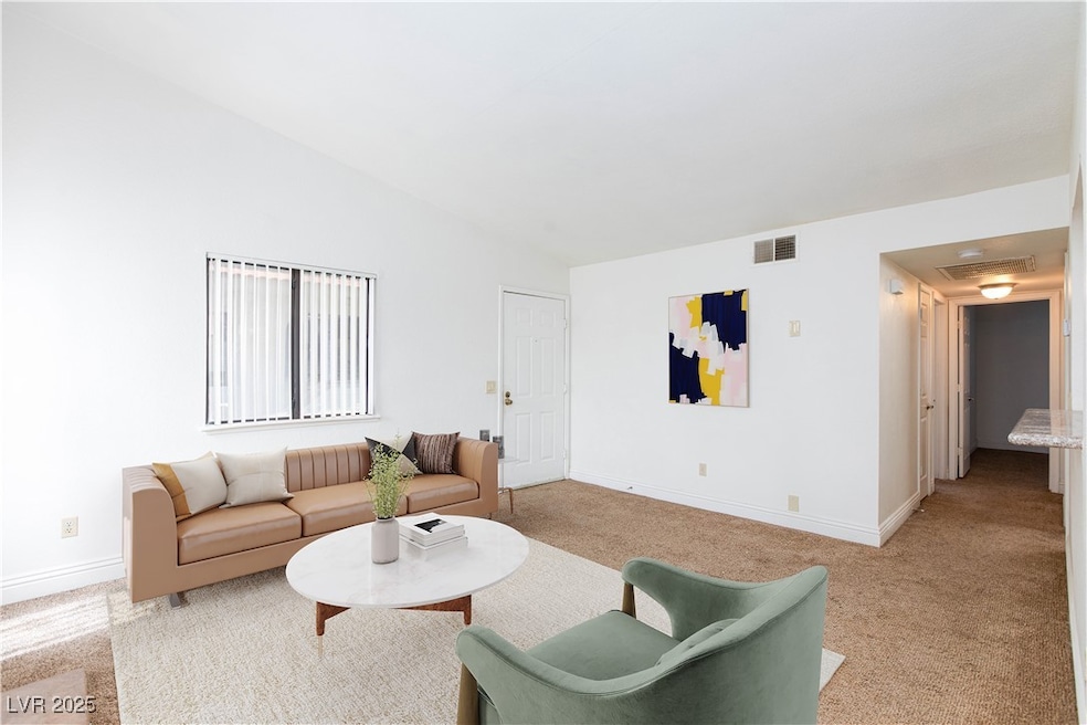 Living area with vaulted ceiling, visible vents, b
