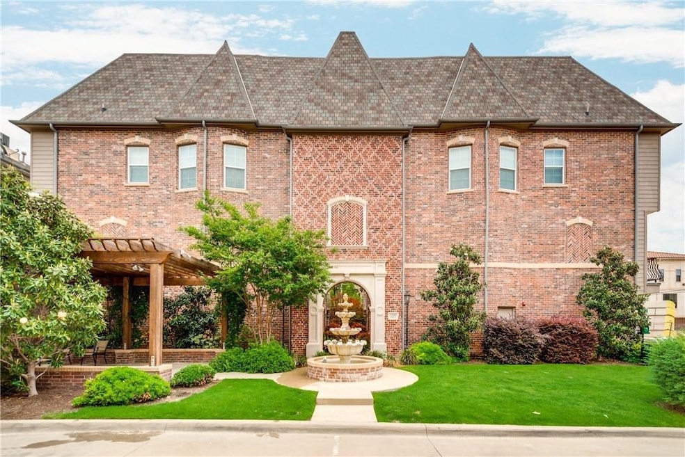 View of front facade with a pergola, a front lawn, brick siding, and a patio area