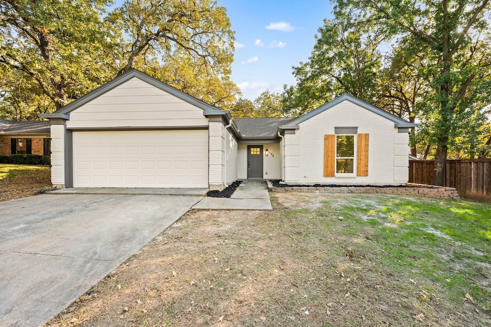 View of front of house featuring concrete driveway, brick siding, and a garage