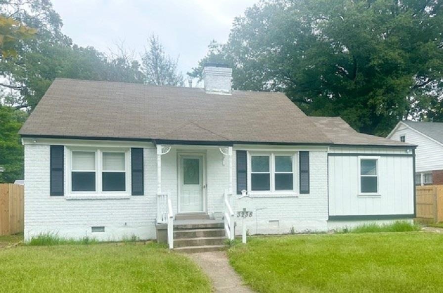 Bungalow-style home with fence, brick siding, a fr