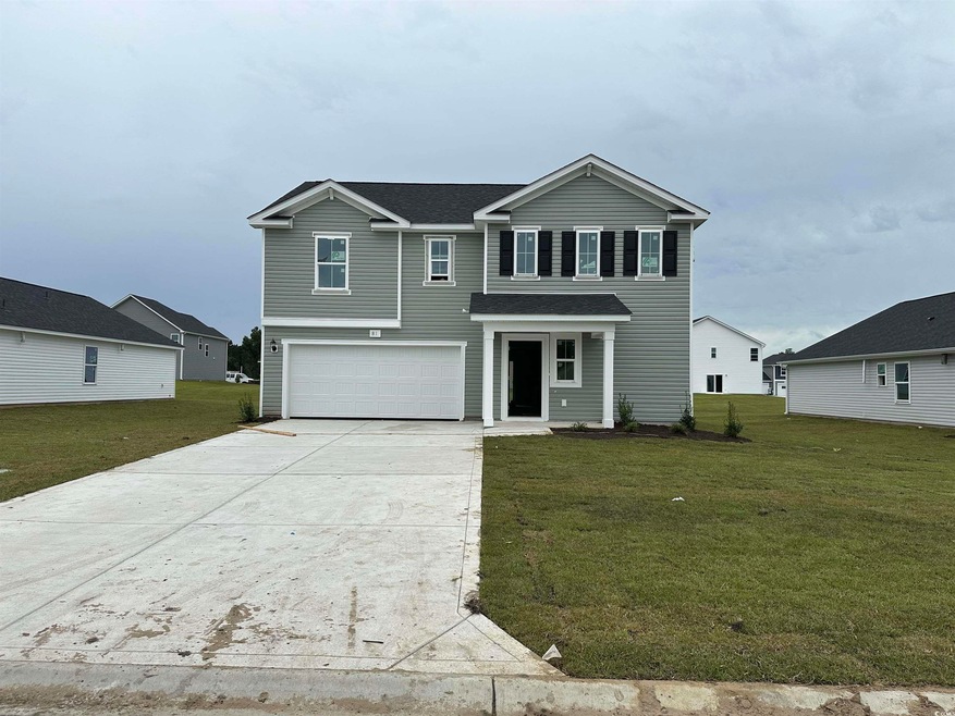 View of front property with a front yard and a gar