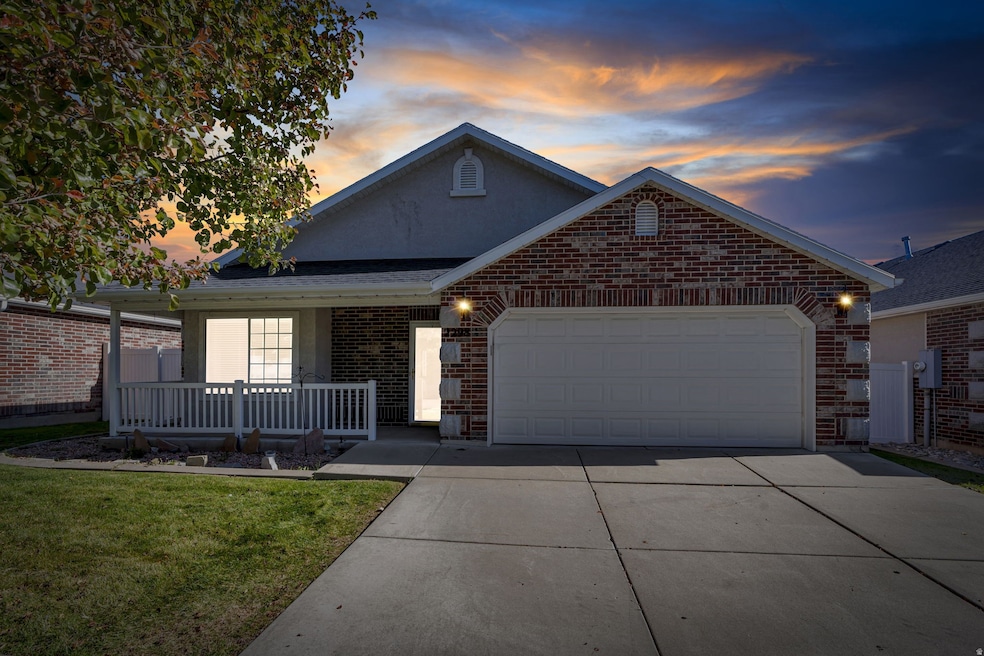View of front of house with driveway, a garage, brick siding, a porch, and roof with shingles