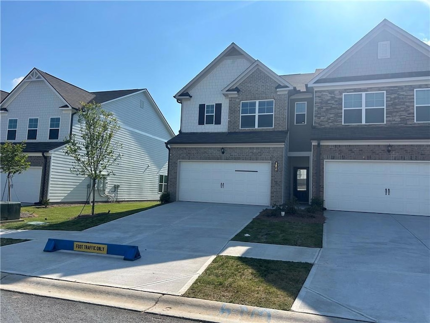 Craftsman inspired home featuring concrete driveway, brick siding, and a garage