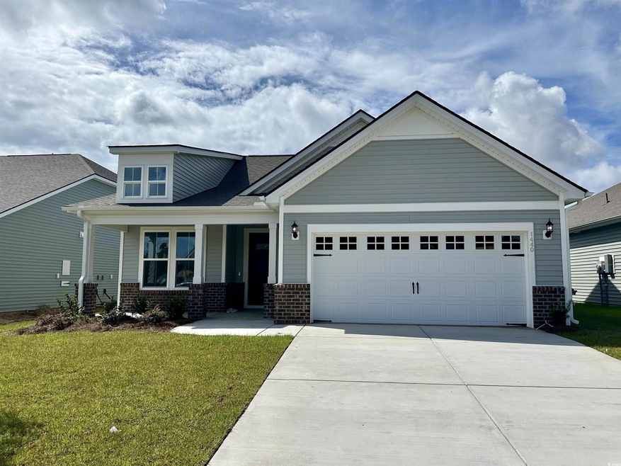 View of front of property featuring brick siding, a garage, driveway, and a front lawn