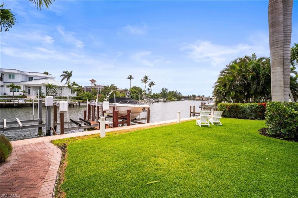 Dock area featuring boat lift, a yard, and a water view