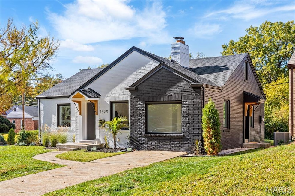 View of front of property featuring a front yard, brick siding, a chimney, and a shingled roof