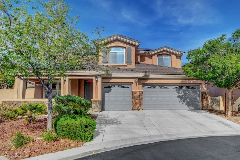 View of front of house featuring an attached garage, driveway, stone siding, and stucco siding