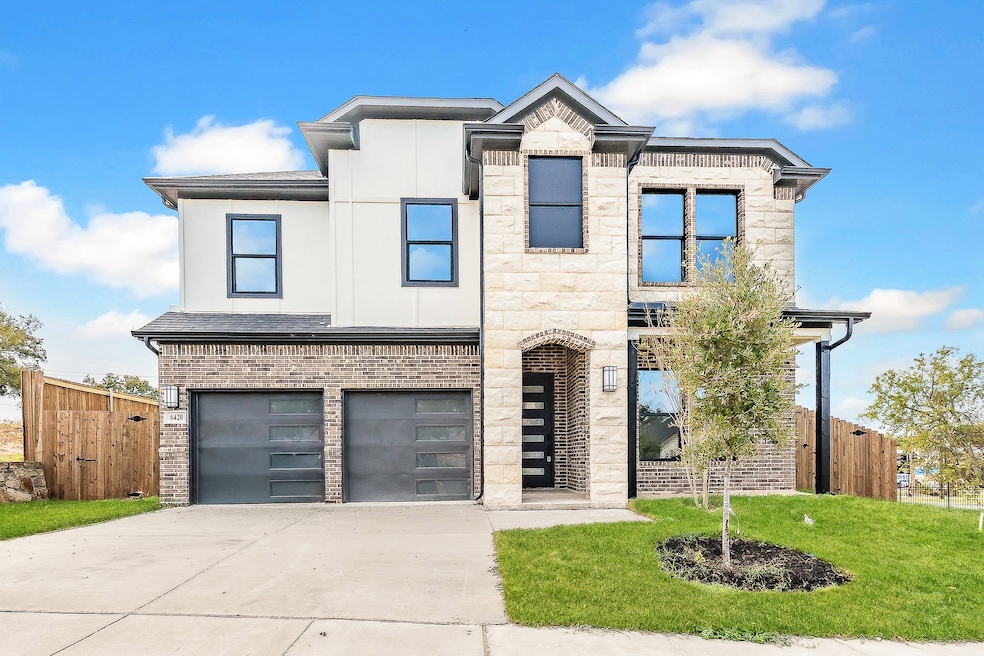 Contemporary home featuring driveway, an attached garage, and brick siding