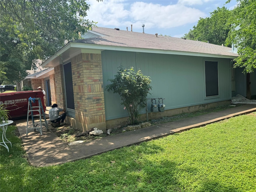 View of property exterior featuring a lawn, brick