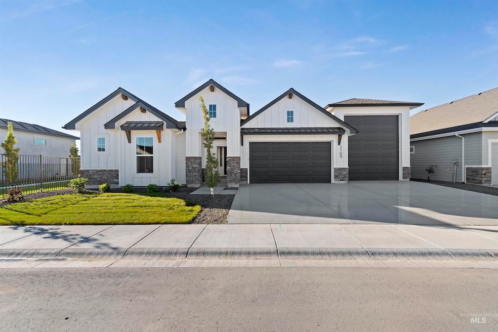 Modern farmhouse style home with board and batten siding, a standing seam roof, and driveway