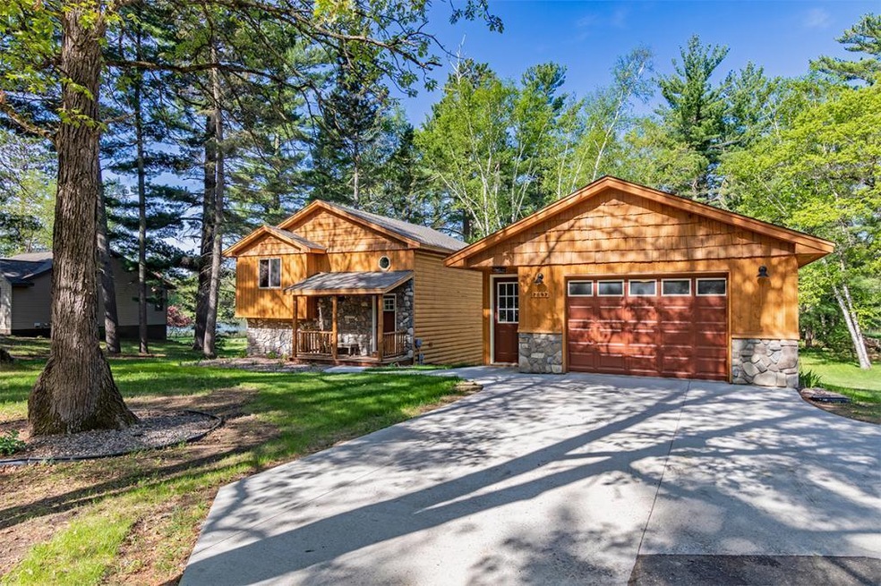 This pine-shaded frontage and beautiful log siding