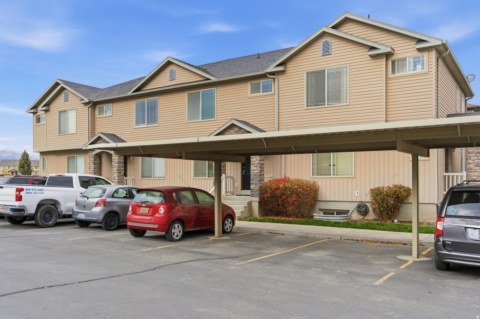 View of front of house featuring covered and uncovered parking and a shingled roof