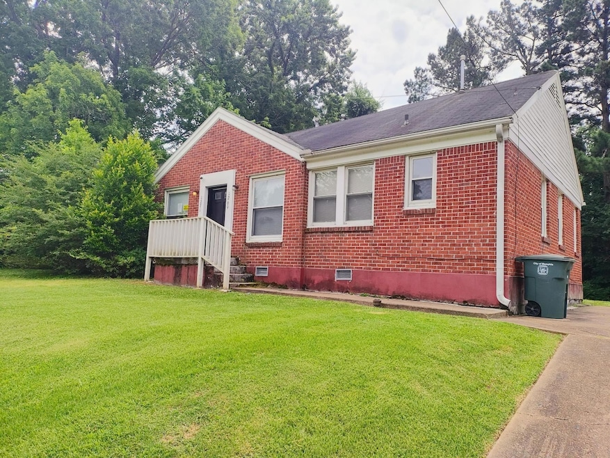 Bungalow featuring brick siding and a front yard