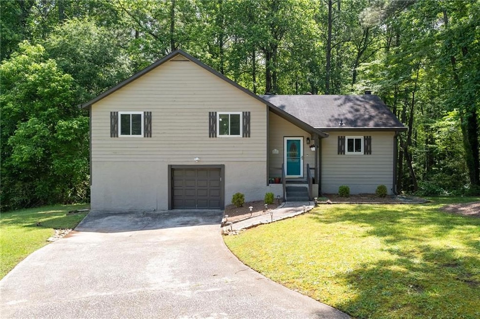 Tri-level home with driveway, a front lawn, an att