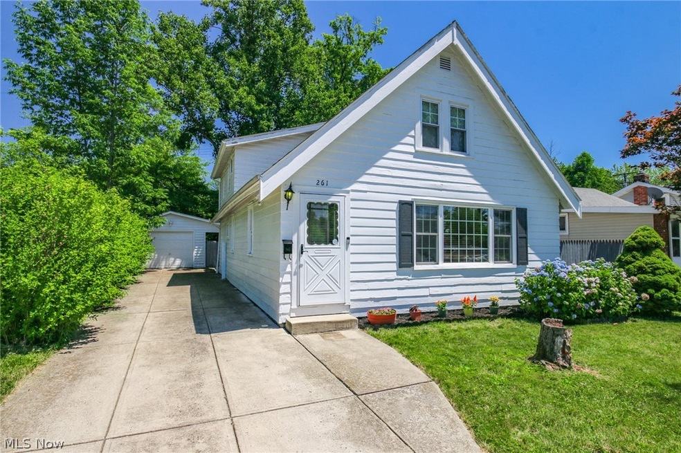 Bungalow-style home featuring an outdoor structure, a garage, and a front lawn