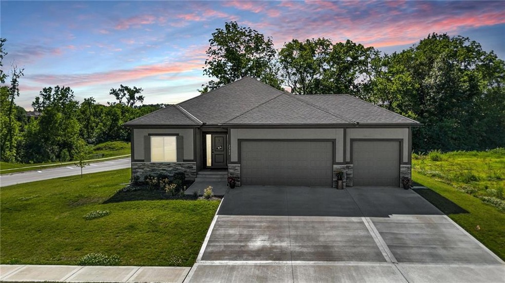 View of front of property featuring a garage and a yard