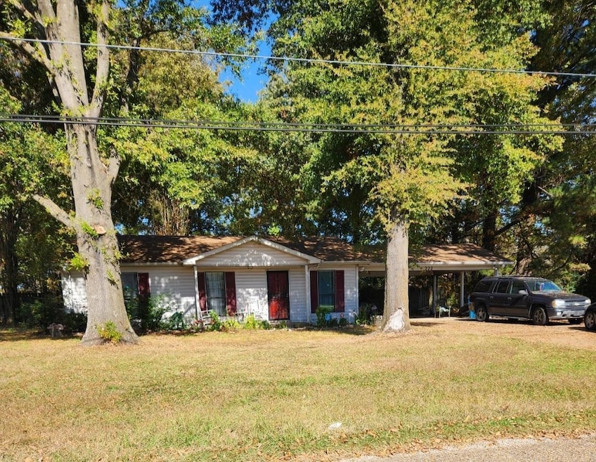 Ranch-style house with a front yard and a carport