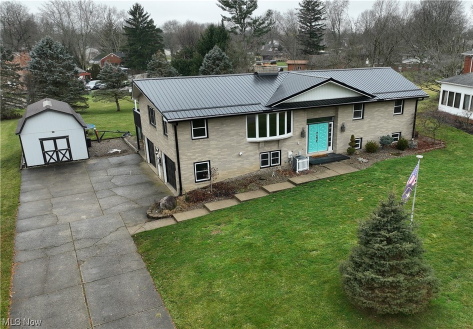 View of front of house featuring a shed and a front yard