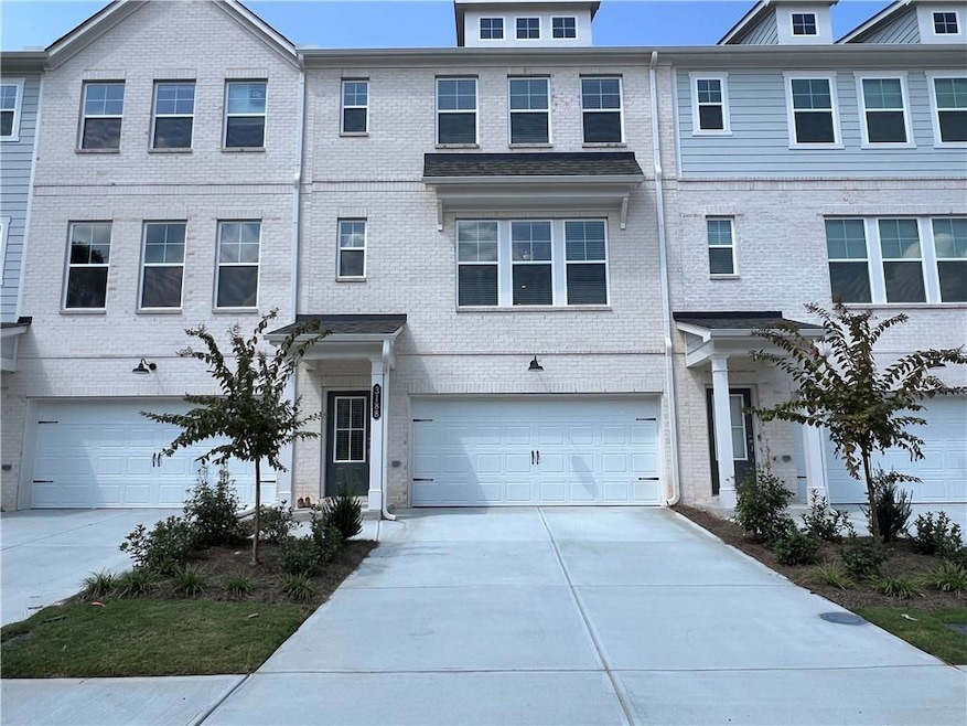 Traditional-style house featuring driveway, brick siding, and a garage