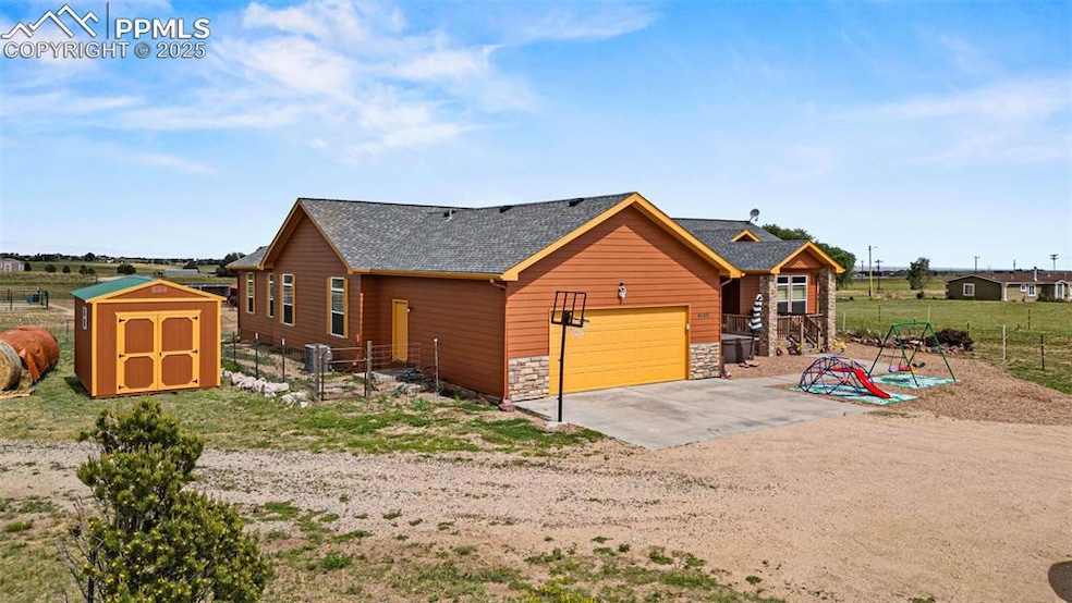 View of front of home featuring roof with shingles, driveway, a garage, and stone siding