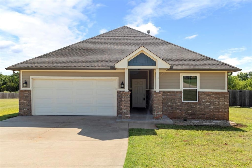Craftsman-style house featuring a garage, a shingled roof, brick siding, and driveway