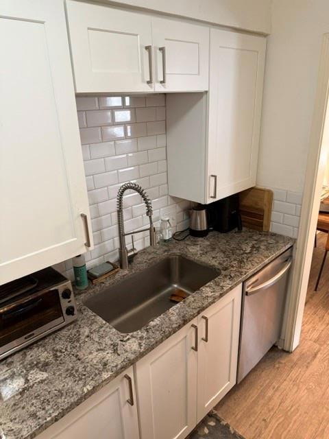 Kitchen featuring dishwasher, light wood-type flo