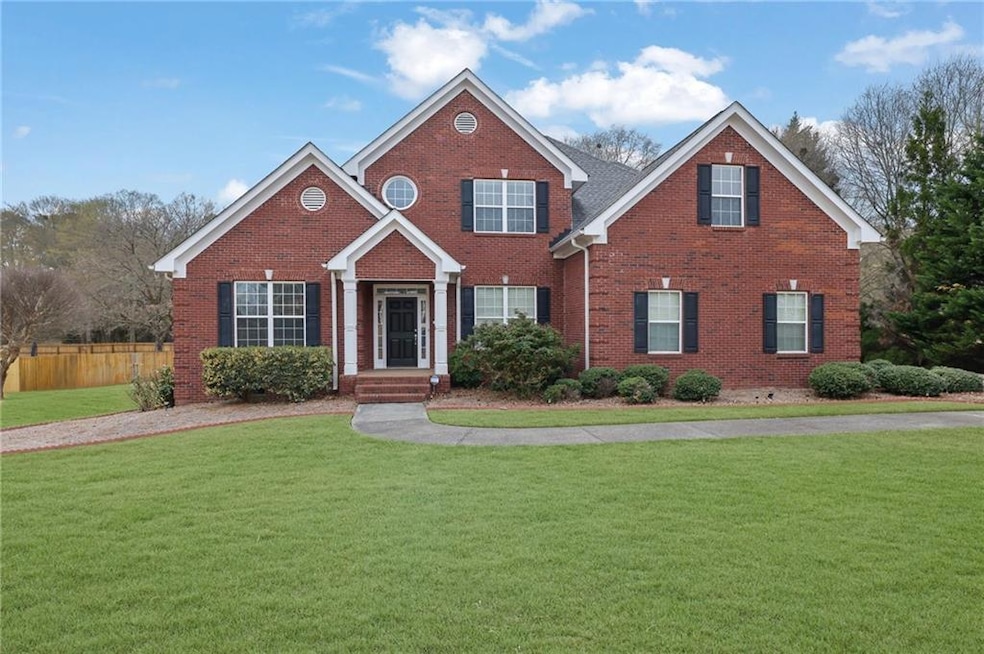 Traditional home featuring brick siding, fence, an