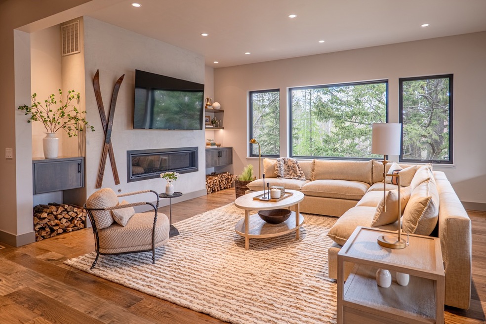 Living area with recessed lighting, visible vents, a glass covered fireplace, and wood finished floors