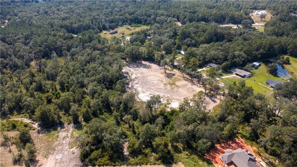 Aerial view of property and surrounding area with a heavily wooded area