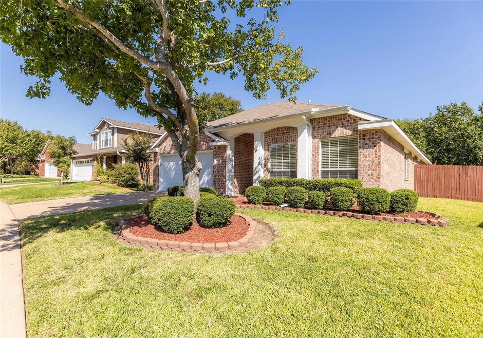 View of front of house featuring a front lawn and a garage