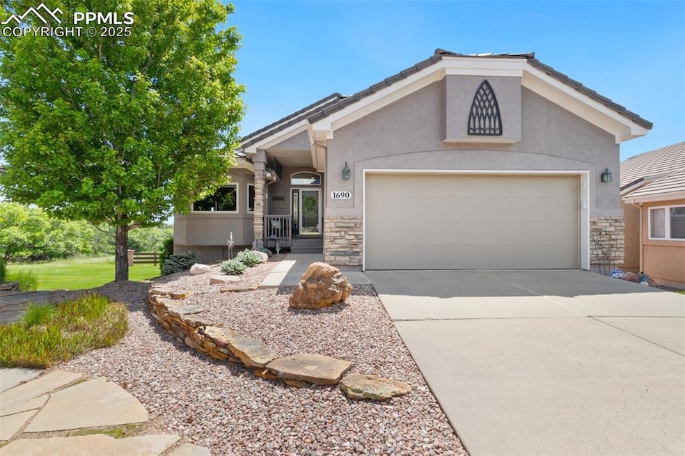 Ranch-style home with stone siding, concrete driveway, and stucco siding