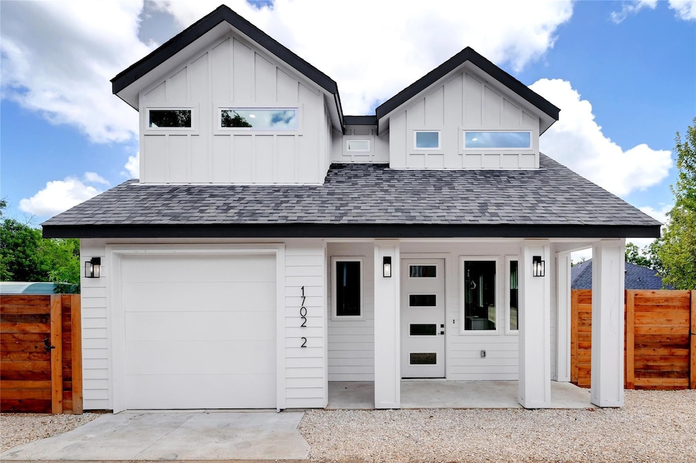 Modern farmhouse style home featuring fence, boar