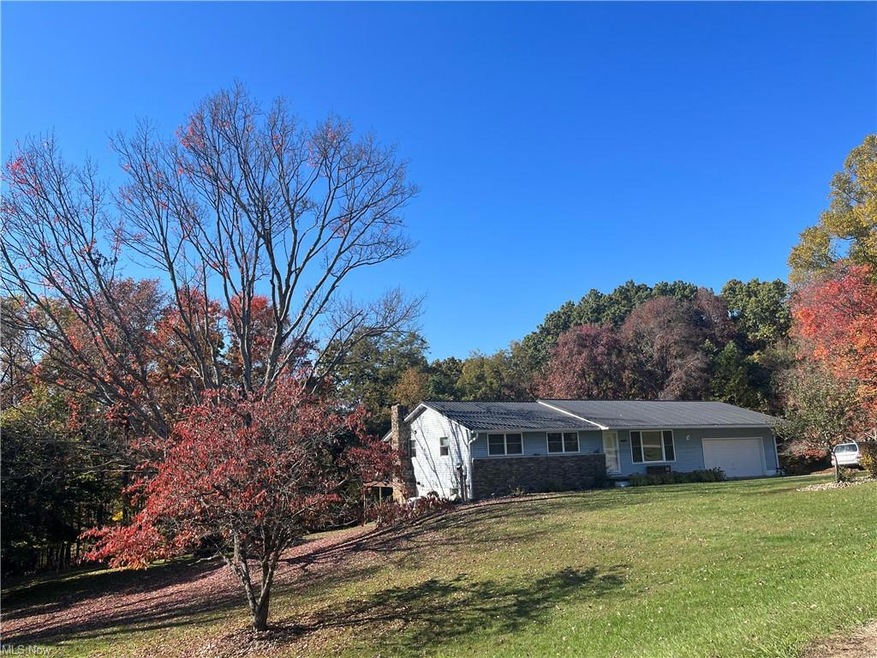 View of front of home with a garage and a front lawn