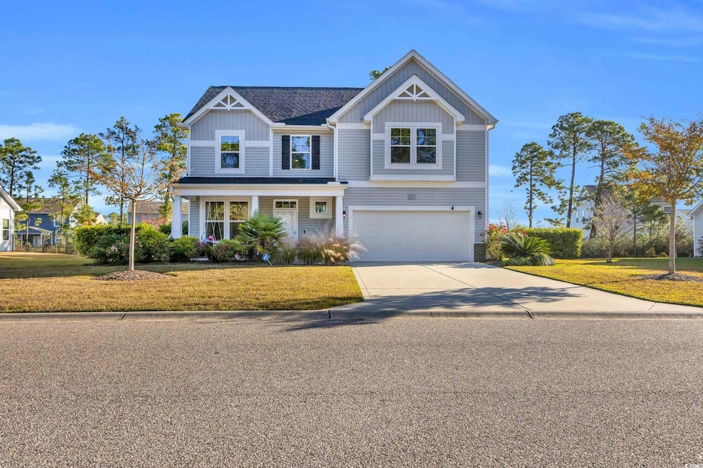 View of front of home with a garage and a front lawn
