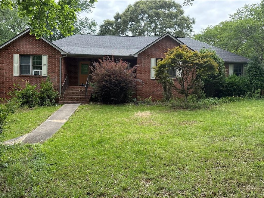 Single story home with brick siding, a front lawn,