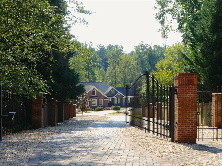 Gated entrance to home with a key. Notice long dri