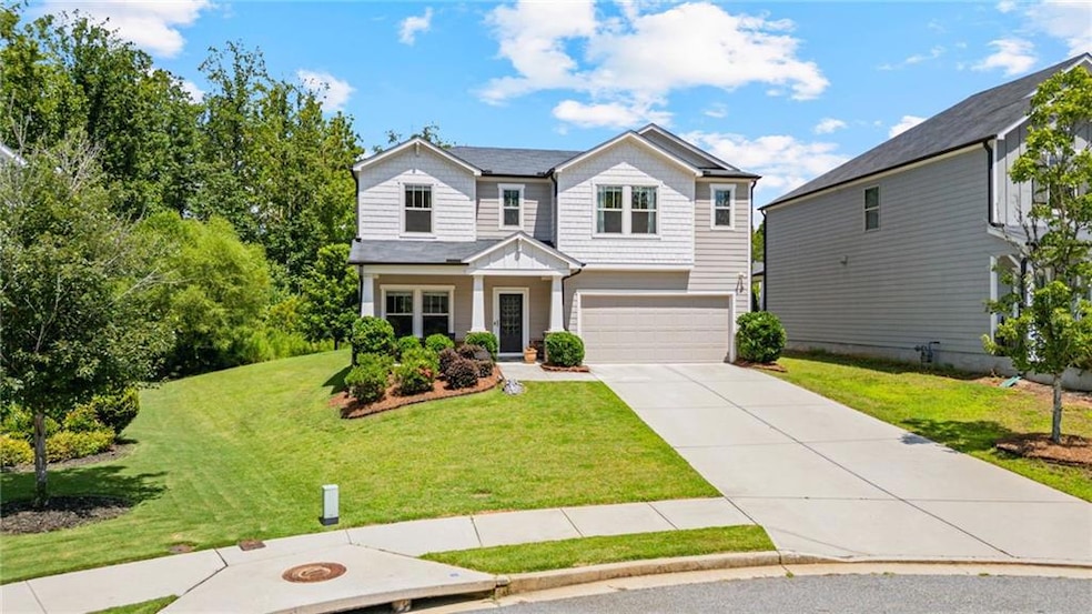 View of front facade with a garage, driveway, and a front yard