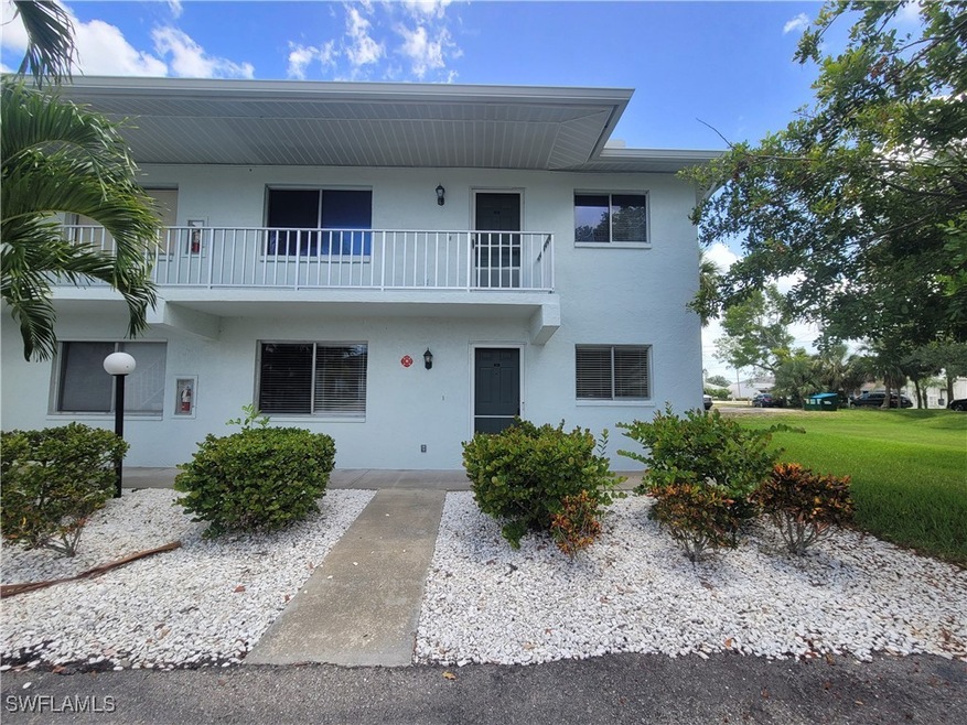 View of front facade featuring a balcony and a front lawn