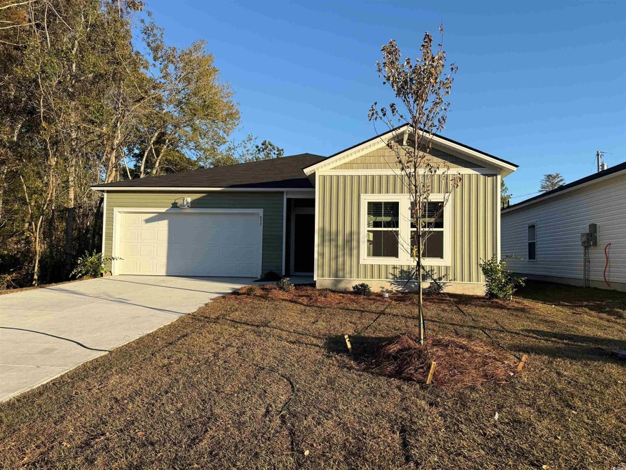 View of front of property featuring board and batten siding, concrete driveway, and a garage
