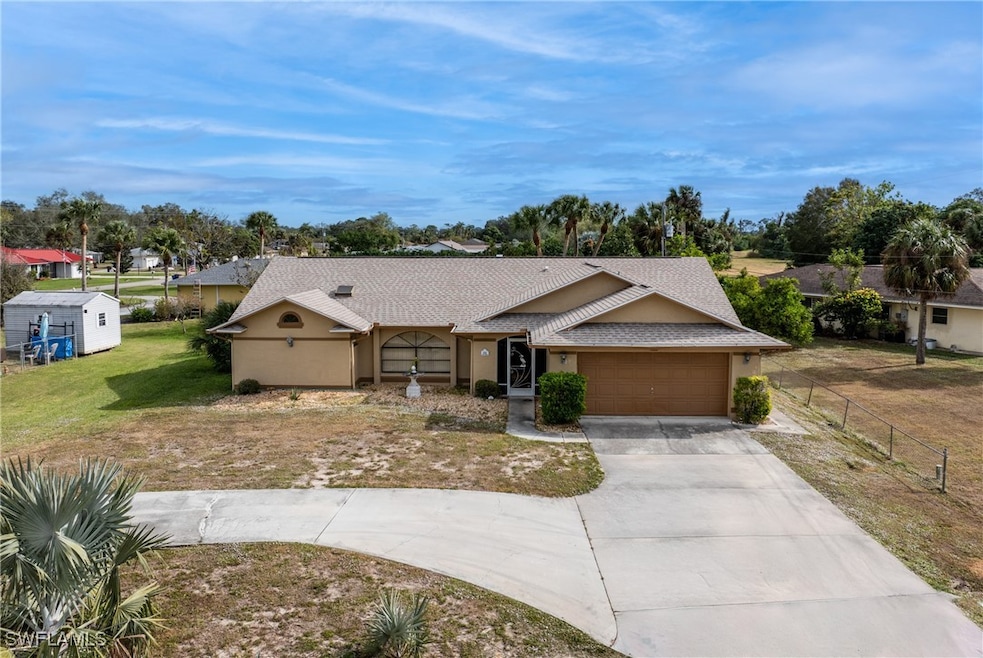 Ranch-style house featuring a front lawn and a gar