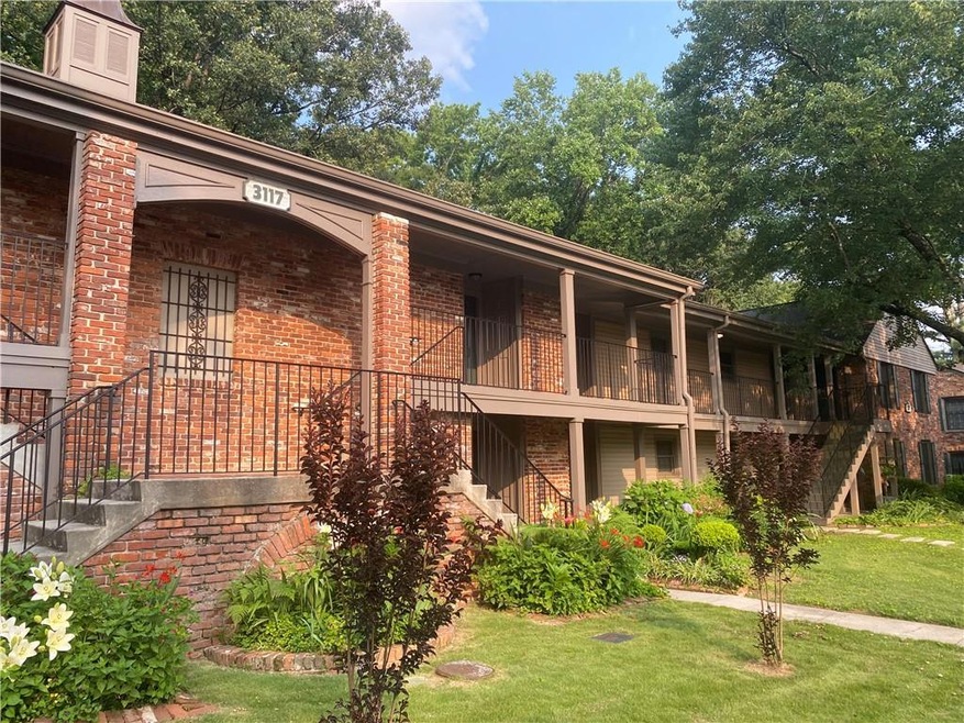 View of property exterior with stairs, brick siding, a yard, and a chimney