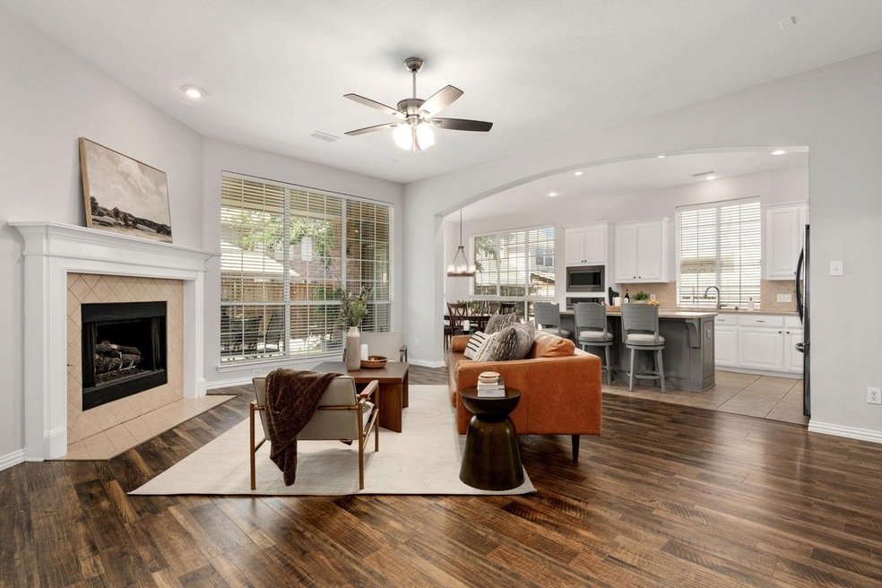 Living room featuring hardwood / wood-style floors, ceiling fan, a tile fireplace, and sink