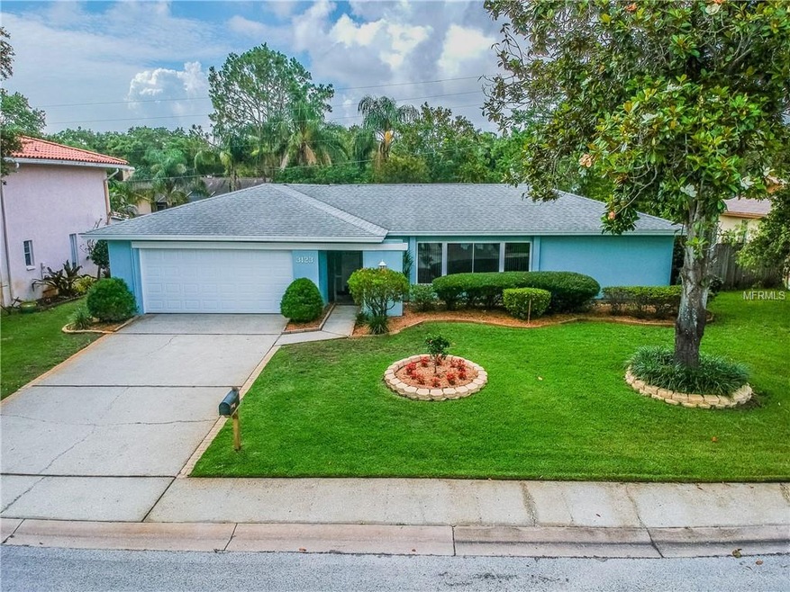 Front of home with manicured landscaping and plent