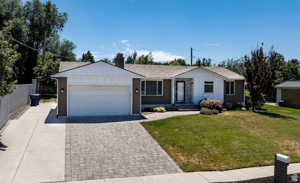 Ranch-style home featuring driveway, board and batten siding, a garage, and brick siding