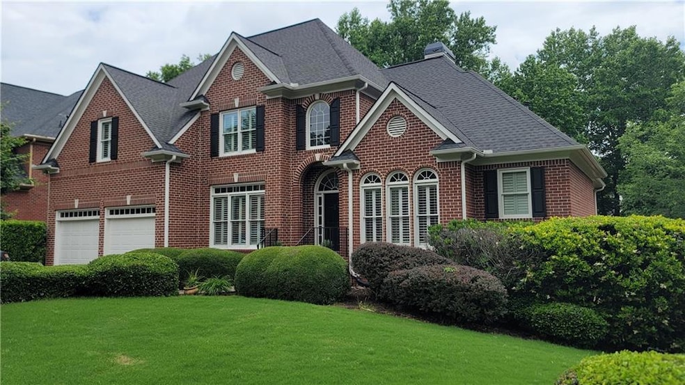 Georgian-style home with brick siding, a garage, a