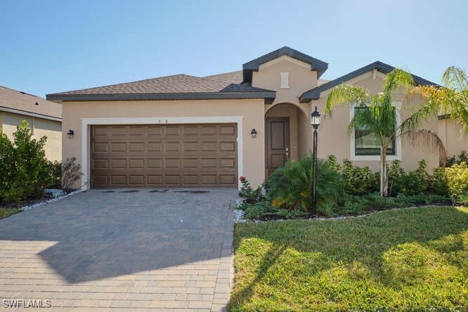 View of front of home with a front yard and a gara